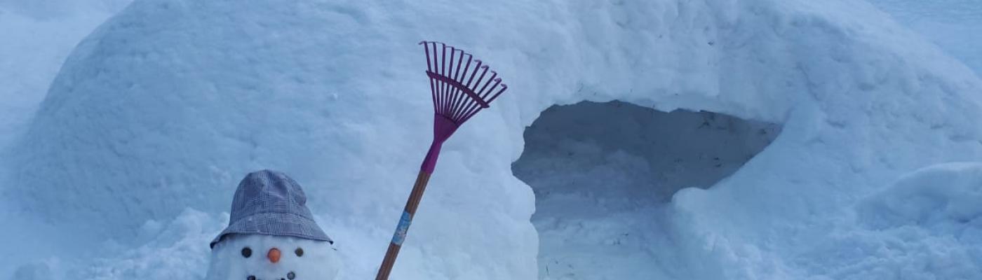 Ein Schneemann bewacht das Iglu 