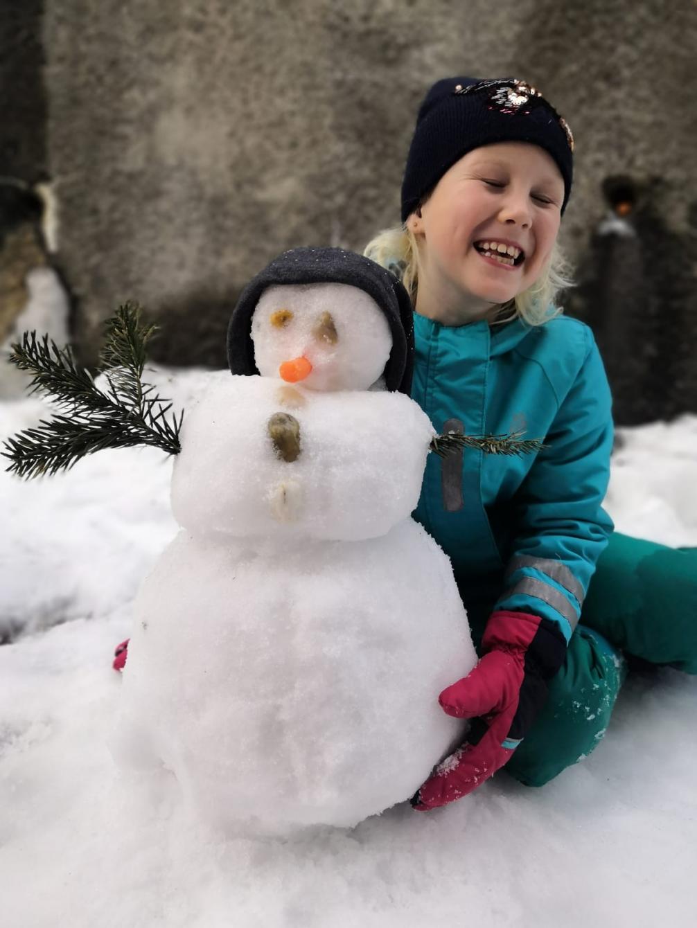 Eva mit ihrem kleinen, lustigen Schneemann 